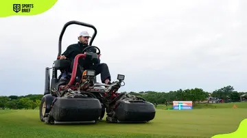 A member of the course grounds crew prepares the ground