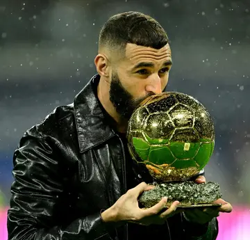 Real Madrid's French forward Karim Benzema poses for pictures with his Ballon d'Or trophy