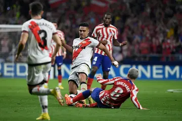 Rayo Vallecano's Colombian forward Radamel Falcao (C) fights for the ball with Atletico Madrid's French forward Antoine Griezmann