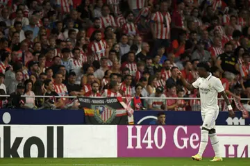 Vinicius Junior gestures at Atletico Madrid fans who aimed objects and racist chants at the Brazilian