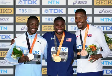 Gold medalist, Noah Lyles is flanked by silver medalist, Letsile Tebogo and bronze medalist, Zharnel Hughes during the men's 100m medal ceremony at the World Athletics Championships in Budapest, Hungary.