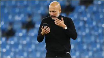 Pep Guardiola talks on his phone after the UEFA Champions League Group A match between Manchester City and Club Brugge KV at Etihad Stadium. Photo by Matthew Ashton.