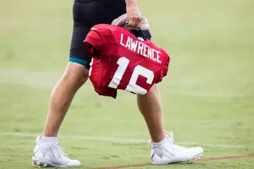 Trevor Lawrence holds his shoulder pads