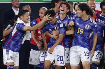 Japan players celebrate scoring in their victory against Germany