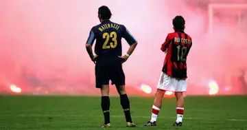 Marco Materazzi of Inter Milan and Rui Costa of AC Milan look on as Inter fans shower the pitch with flares during the UEFA Champions League quarter-final match at the San Siro Stadium. Photo by Mike Hewitt.