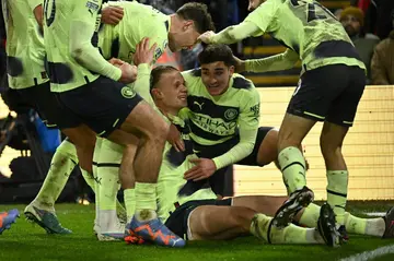Manchester City striker Erling Haaland (C) celebrates with team-mates
