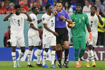 Ghana's players protest a decision by US referee Ismail Elfath to award a penalty to Portugal