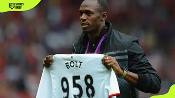 Usain Bolt poses with a Manchester United shirt