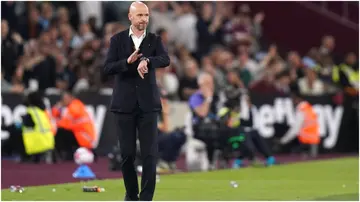 Erik ten Hag taps his watch during the Premier League match between Man United and West Ham at the London Stadium. Photo by Adam Davy.