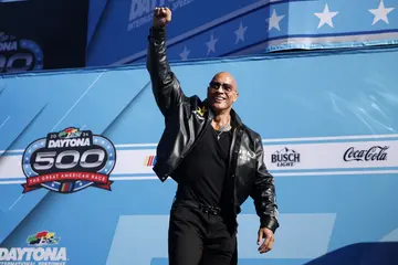 Dwayne “The Rock” Johnson waves to fans as he walks onstage during a pre-race ceremony at the NASCAR Cup Series Daytona 500