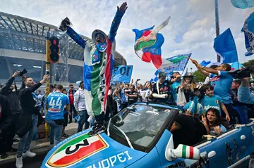 Title drive: Napoli fans outside the stadium with a car painted in anticipation of the club's third league title