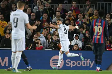 Real Madrid forward Karim Benzema (C) celebrates after scoring his team's third goal against Barcelona at Camp Nou