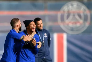 Kylian Mbappe laughs as he is grabbed by  Sergio Ramos in training ahead of the Benfica game