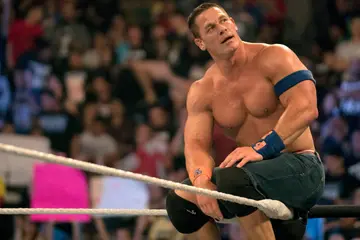 John Cena sitting on ropes during a match