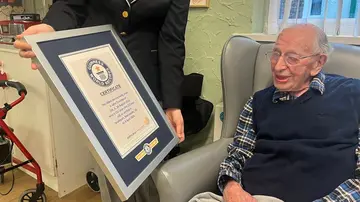 John Tinniswood poses with his certificate from the Guinness World Records, who announced that he is the world's oldest living man, in Southport, Britain April 4, 2024