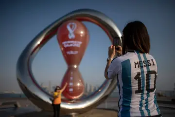 An Argentine fan takes a picture next to the World Cup countdown clock in Doha, Qatar.