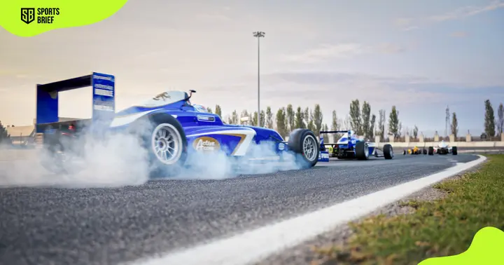 Blue Formula racing cars are pictured on the track.