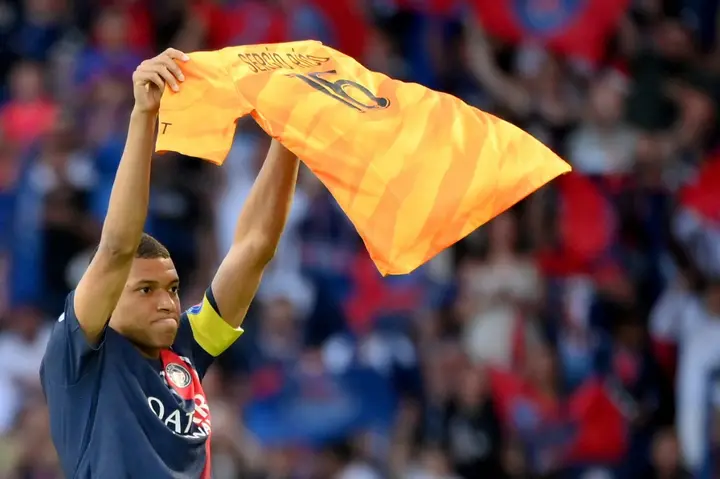 Kylian Mbappe holds up Sergio Rico's jersey after scoring for PSG against Clermont