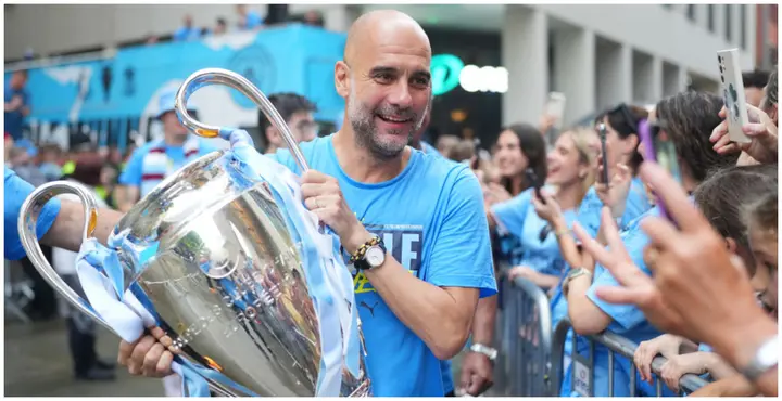 Man City boss Pep Guardiola carries the UEFA Champions League trophy during the Manchester City trophy parade. Photo by Lexy Ilsley.