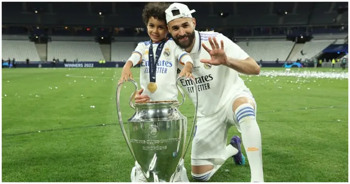 Karim Benzema celebrates with family and the UEFA Champions League trophy during the UEFA Champions League final match between Liverpool FC and Real Madrid. Photo by Alexander Hassenstein.