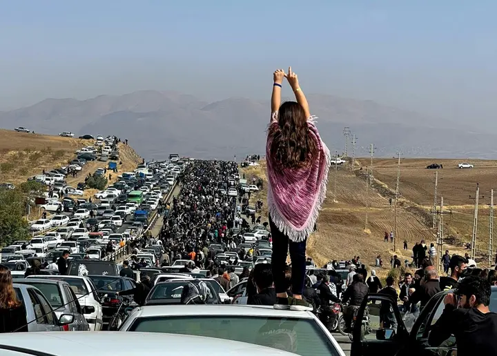 This image posted on Twitter reportedly on October 26, 2022 shows an unveiled woman standing atop a vehicle in Saqez, Mahsa Amini's home town in the western Iranian province of Kurdistan, to mark 40 days since her death