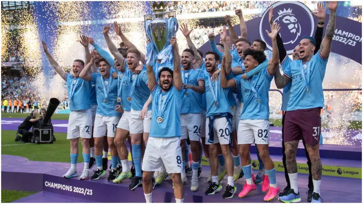Manchester City captain Ilkay Gundogan lifts the Premier League trophy in front of teammates at Etihad Stadium. Photo by Visionhaus.