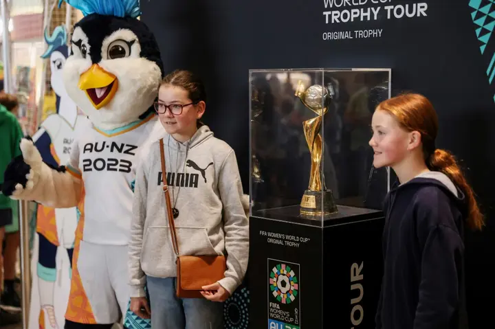 People pose with the trophy for the Women's World Cup at a shopping mall in Auckland